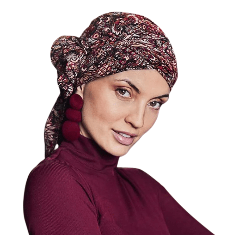 Frau trägt Juvela Turban mit floralem Folklore-Muster, Stirnband und roten Ohrringen