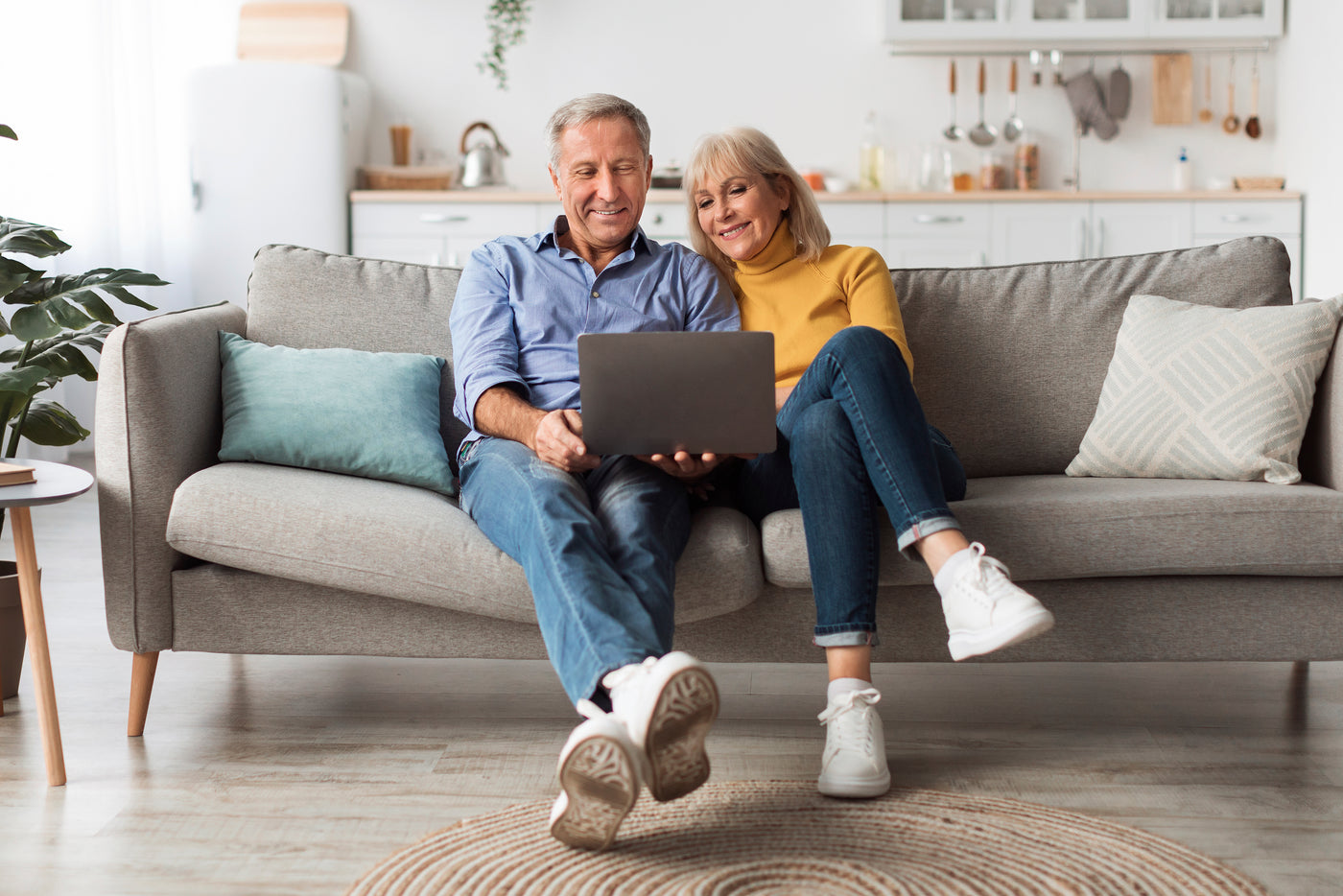 Par sidder i sofaen og kigger på en computer sammen