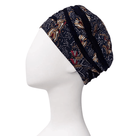Shanti Turban im Amber Garden Print, von der Seite auf weißer Schaufensterpuppe, mit dunkelblauem Grund und Feder- und Stamm-Motiv