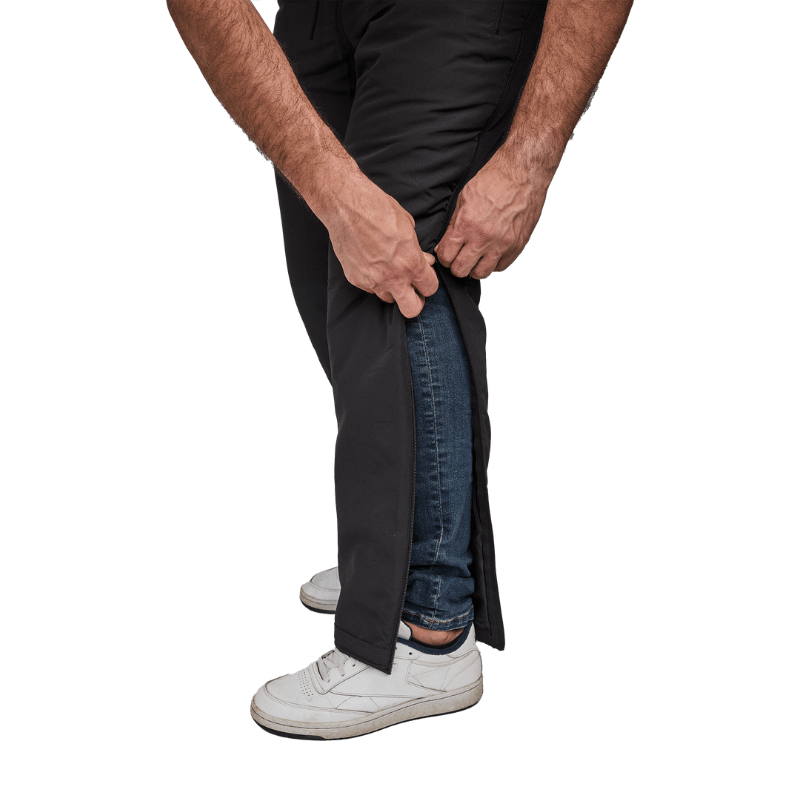 Nahaufnahme von Händen, die Dobsom Thermohose seitlich über Jeans öffnen